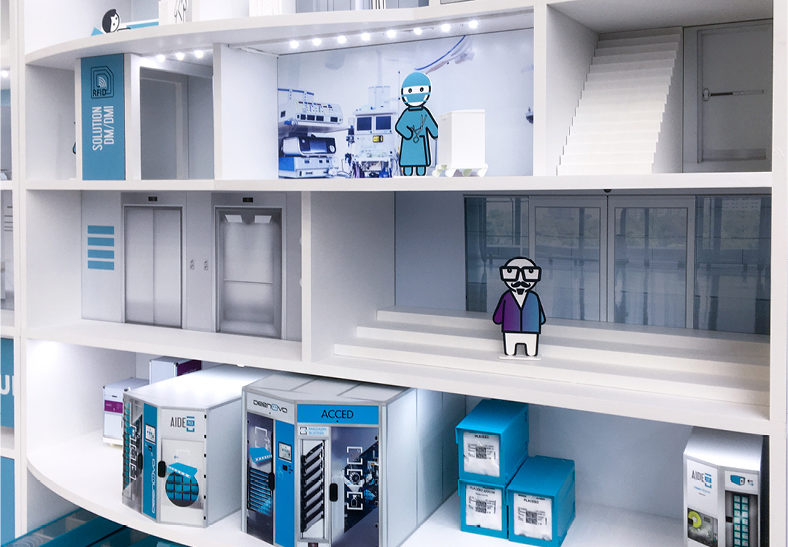 Détail de l’hôpital au 1/10e créé par Atribu pour le stand Deenova France, fabrication d’une coupe de bâtiment avec des personnages et des automates